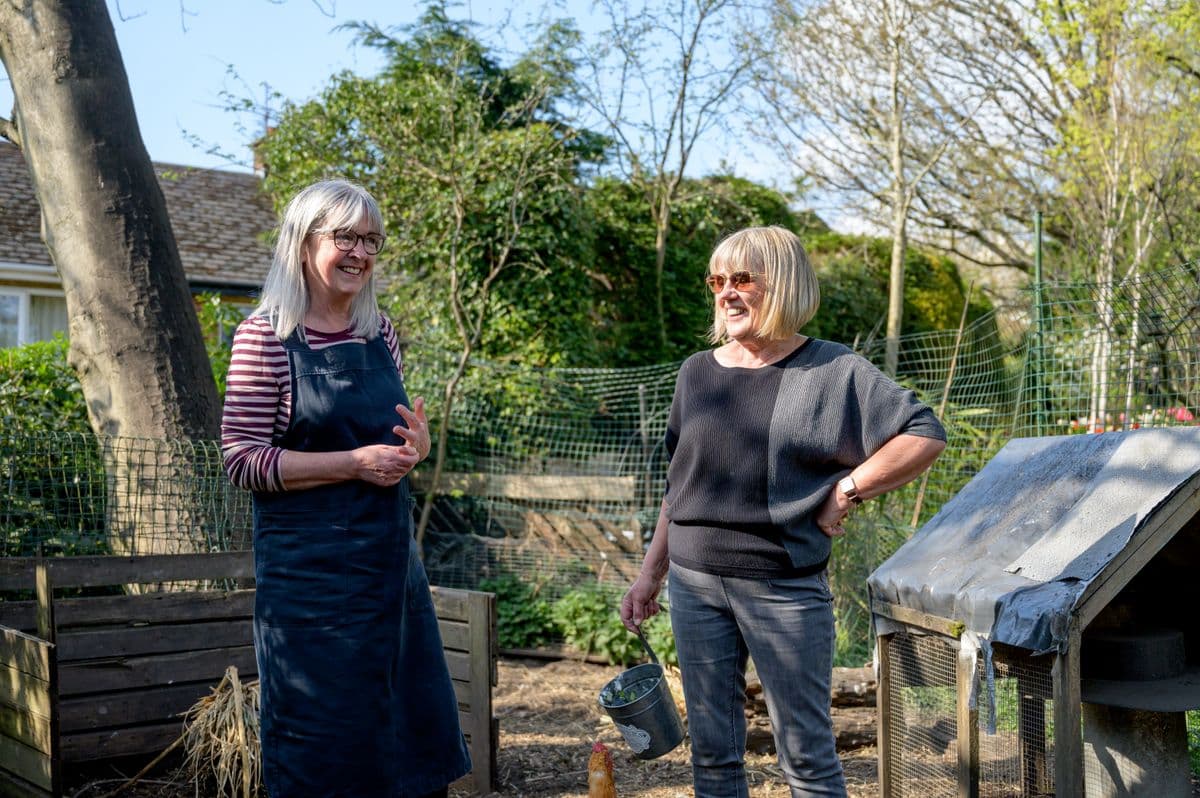 Two women talking together in a garden