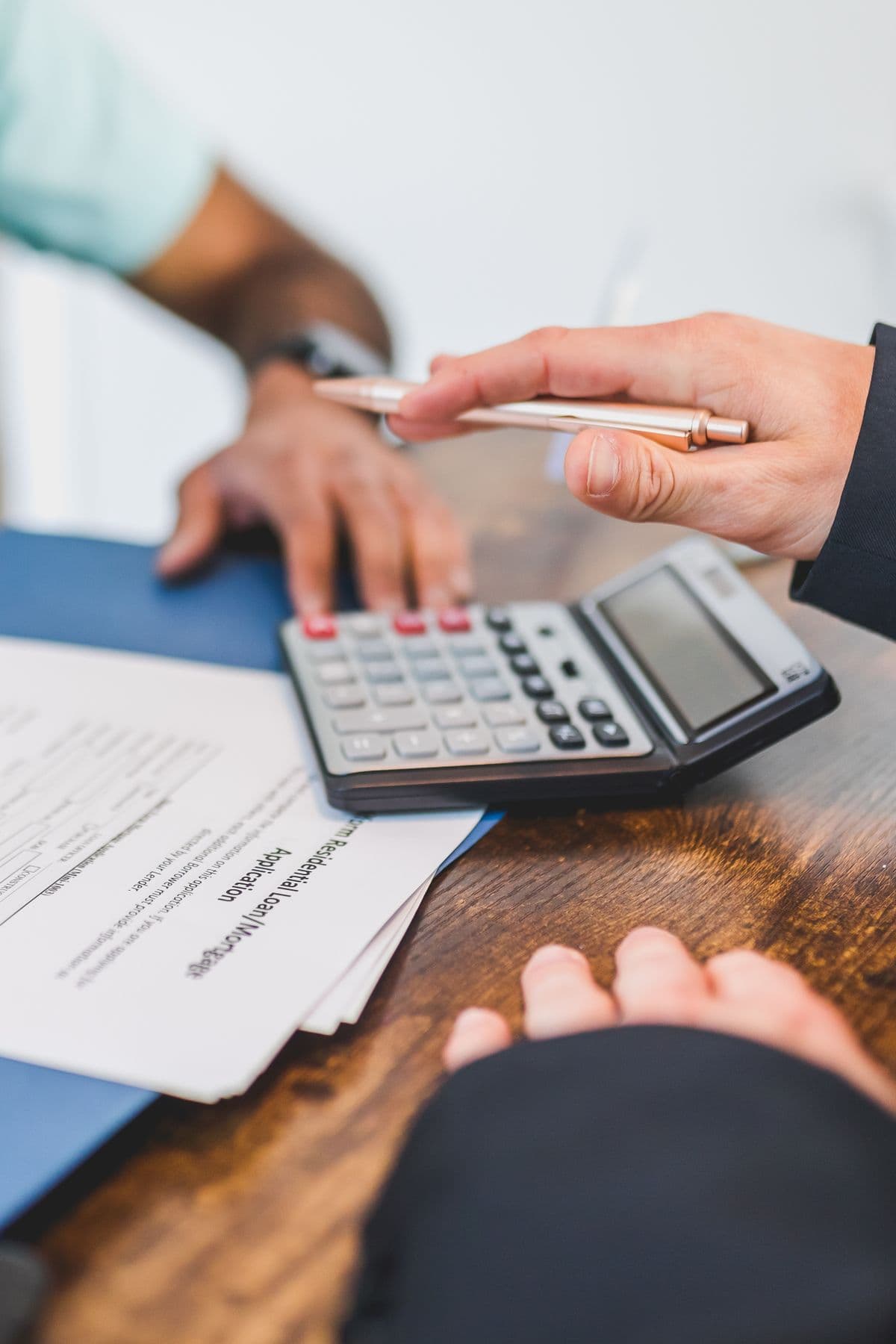 Hands reviewing documents with a calculator