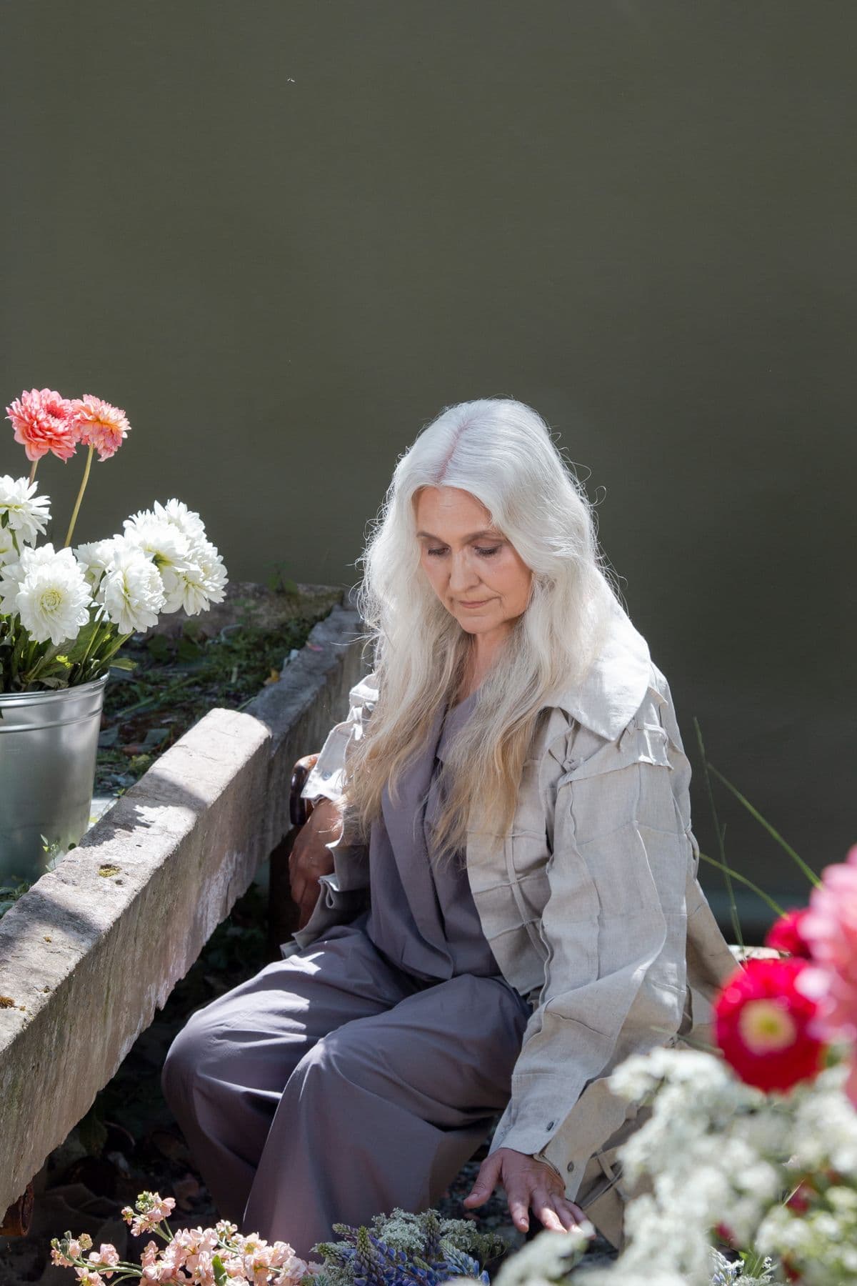 A woman enjoying a quiet moment among flowers
